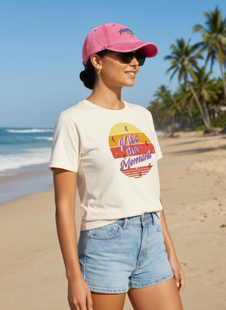 Woman wearing a vintage-style pink cap with embroidered logo, standing on a sunny beach. Retro Y2K fashion accessory from TendingTrends.