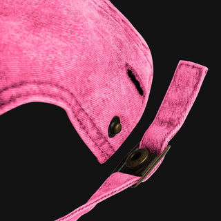 Detailed close-up of the adjustable strap and brass buckle on a vintage pink dad cap.